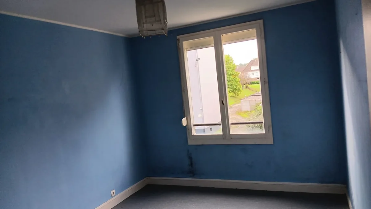 Chambre repeinte dans un bleu profond, encadrement de fenêtre repris