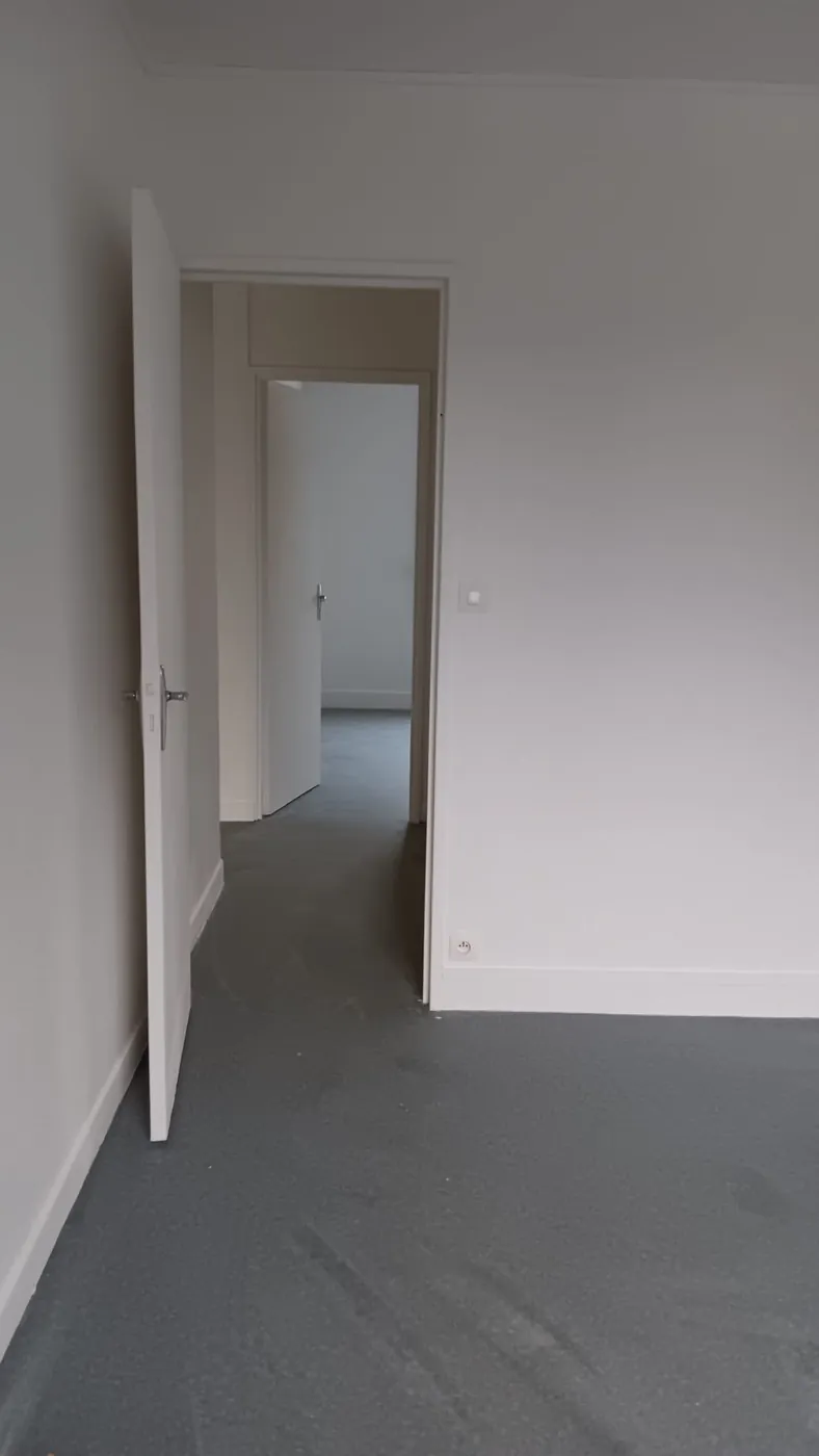 Couloir rénové, portes et plinthes repeintes, sol souple posé