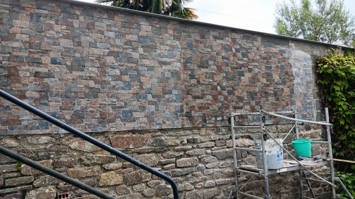 Mur de soutènement habillé en parement de pierre, main courante le long de l'escalier